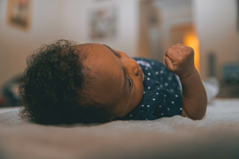A newborn baby resting on a soft blanket