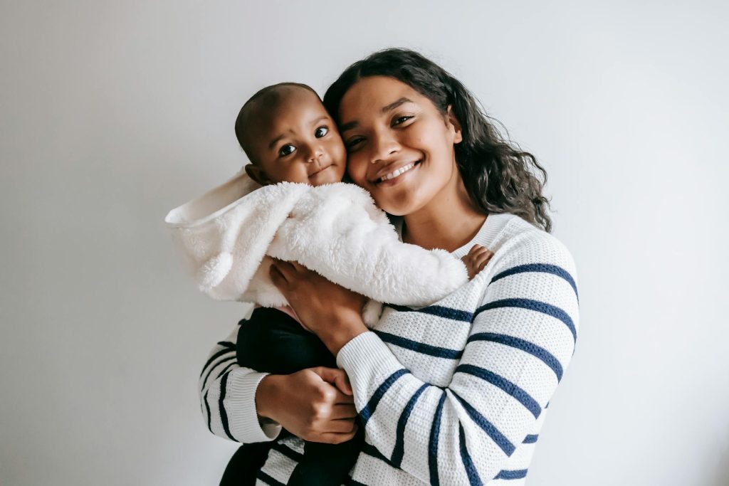 A smiling mother hugging her baby