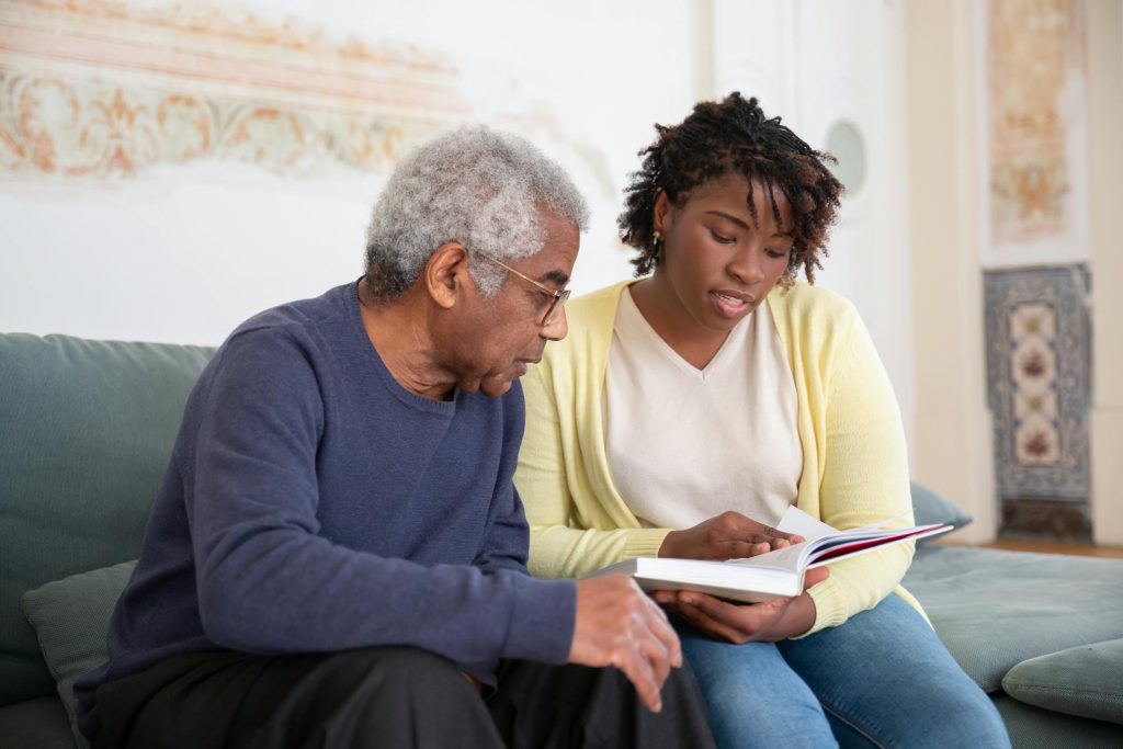 A caregiver reading with an elderly man
