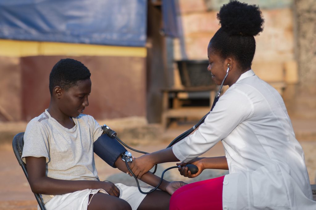 A nurse checking a patient’s blood pressure at home
