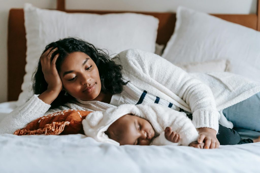 A mother sleeping peacefully beside her baby